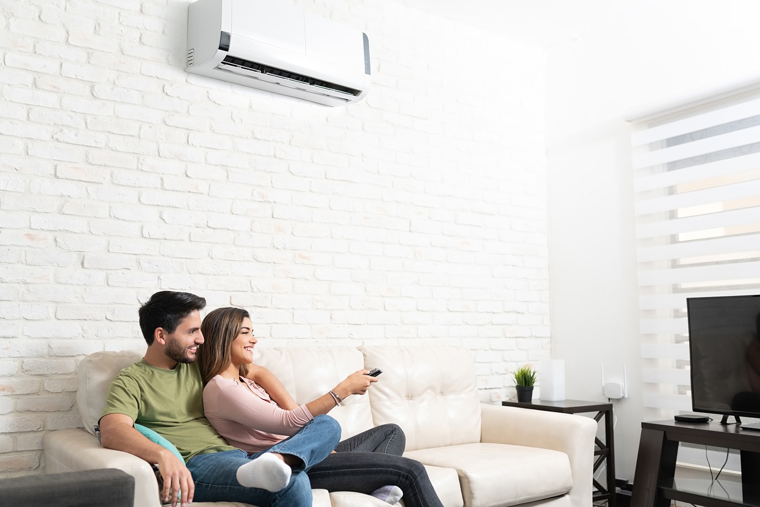 Smiling,Hispanic,Couple,Watching,Tv,While,Relaxing,On,Sofa,In